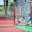 Des enfants profitent de Youth Double Swing dans une aire de jeux.