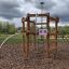 Sherwood wooden playhouse dans un parc entouré d'arbres.