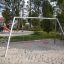 Silver Double Swing dans une aire de jeux avec du sable et des équipements de parc à proximité.