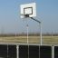 Panier de basket extérieur avec une clôture métallique noire dans une aire de sport.