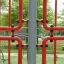 Structure d'escalade rouge de l'équipement de jeu Shea dans un parc verdoyant.