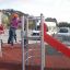 Des enfants jouent sur le Junior single slide avec structure d’escalade.