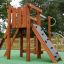 Stranda wooden playhouse avec mur d’escalade et toboggan dans une aire de jeux.