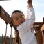 Un enfant jouant sur Kampinos wooden playhouse.