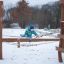 Un enfant joue sur un pont de corde dans une aire de jeux extérieure en hiver.