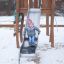 Un enfant glisse sur un toboggan d'aire de jeux Alv en hiver.
