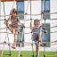 Enfants grimpant sur un filet de corde Nature Ship Sandbox, wooden playhouse.