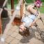 Enfant jouant sur le filet de corde du Nature Ship Sandbox, wooden playhouse.