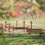 Larchwood Bench dans une aire de jeux avec des structures d’escalade en bois en arrière-plan.