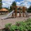 Ensemble d’équipements de jeu Alstad avec toboggan, mur d’escalade et structures en bois.