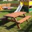 Larchwood Table & Bench dans une aire de jeux avec un toboggan en arrière-plan