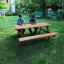 Larchwood Table & Bench dans un jardin avec deux personnes assises.