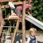 Enfants jouant sur un toboggan d’aire de jeux en bois Bergila.