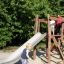 Enfants jouant sur une structure de toboggan d’aire de jeux en bois Bergila.