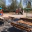 Table en construction acier dans une aire de jeux pour enfants avec des bancs et des structures de jeu à l'arrière-plan