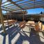 Ensembles d'extérieur en bois Table & Bench sous une pergola en bois dans une zone pavée.