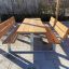Ensemble en bois 'Table & Bench' sur une terrasse, parfait pour s'asseoir en extérieur.