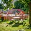 Bancs et table dans une aire de jeux avec structure d'escalade rouge.