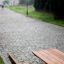 Table et banc de parc en bois sur un chemin pavé.