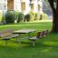 Table & Bench dans un parc verdoyant avec des arbres et des bâtiments en arrière-plan