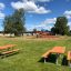 Espace de détente extérieur avec Table & Bench dans un cadre de parc avec aire de jeux.
