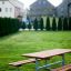 Ensemble Table & Bench dans une zone de parc verdoyante avec des maisons en arrière-plan.