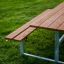 Ensemble extérieur en bois Table & Bench sur une prairie verte.