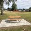 Table & Bench dans un parc avec une aire de jeux en arrière-plan.