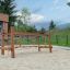 Structure d’escalade en bois pour aire de jeux Dolomiti avec éléments en corde sur surface sablonneuse.