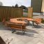School Table & Bench en bois disposé en arrangement hexagonal dans une zone extérieure pavée.