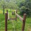 Structure d’escalade en bois pour aire de jeux pour enfants nommée Kongo dans un parc verdoyant.