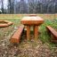 Mobilier extérieur en bois Table & Bench Nature installé dans un jardin de cour arrière.