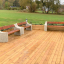 Bancs en bois avec côtés en béton sur une terrasse en bois dans un parc.
