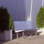 Banc Rosaly entre deux grandes plantes en pot à l'extérieur