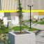 Jardinière en béton Berta avec un arbre en croissance dans un espace d'exposition extérieur.