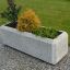 Jardinière rectangulaire en béton Milano avec diverses plantes.