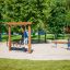 Enfants jouant sur l’équipement de terrain de jeu Barrel dans un parc.