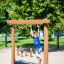 Enfant jouant sur l’équipement de terrain de jeu Barrel dans un parc.