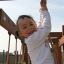 Enfant jouant dans la maisonnette en bois Lianes.