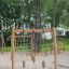 Maison de jeu en bois Lianes dans une aire de jeux avec filets d’escalade et poteaux en bois
