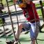 Un enfant grimpe sur Butterfly climbing net dans une aire de jeux.