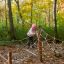 Enfant jouant sur Gossamer structure d’escalade en corde dans une forêt d’automne.