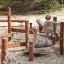Enfants jouant sur un équipement de terrain de jeu en bois Sahara avec pont d’équilibre en extérieur.