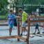 Enfants jouant sur une poutre d’équilibre en bois Sahara pour aire de jeux avec chaînes en extérieur.