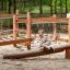 Enfant jouant sur une poutre d’équilibre en bois Sahara dans une aire de jeux forestière