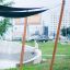 Sun Shades offrant un abri dans un parc urbain moderne avec un enfant assis près d’une fontaine en béton