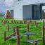 Équipement de terrain de jeu en bois Gobi sur une pelouse verte devant un bâtiment scolaire moderne.