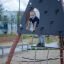 Enfant grimpant sur la structure Tipi II climbing net d’une aire de jeux extérieure