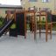 Équipements de jeux Wetpour 60 avec toboggan et structure d’escalade dans un quartier résidentiel.