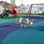 Aire de jeux avec sol de sécurité Wetpour 120 et équipements de jeu extérieurs.